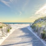 a sandy beach with a path leading to the ocean