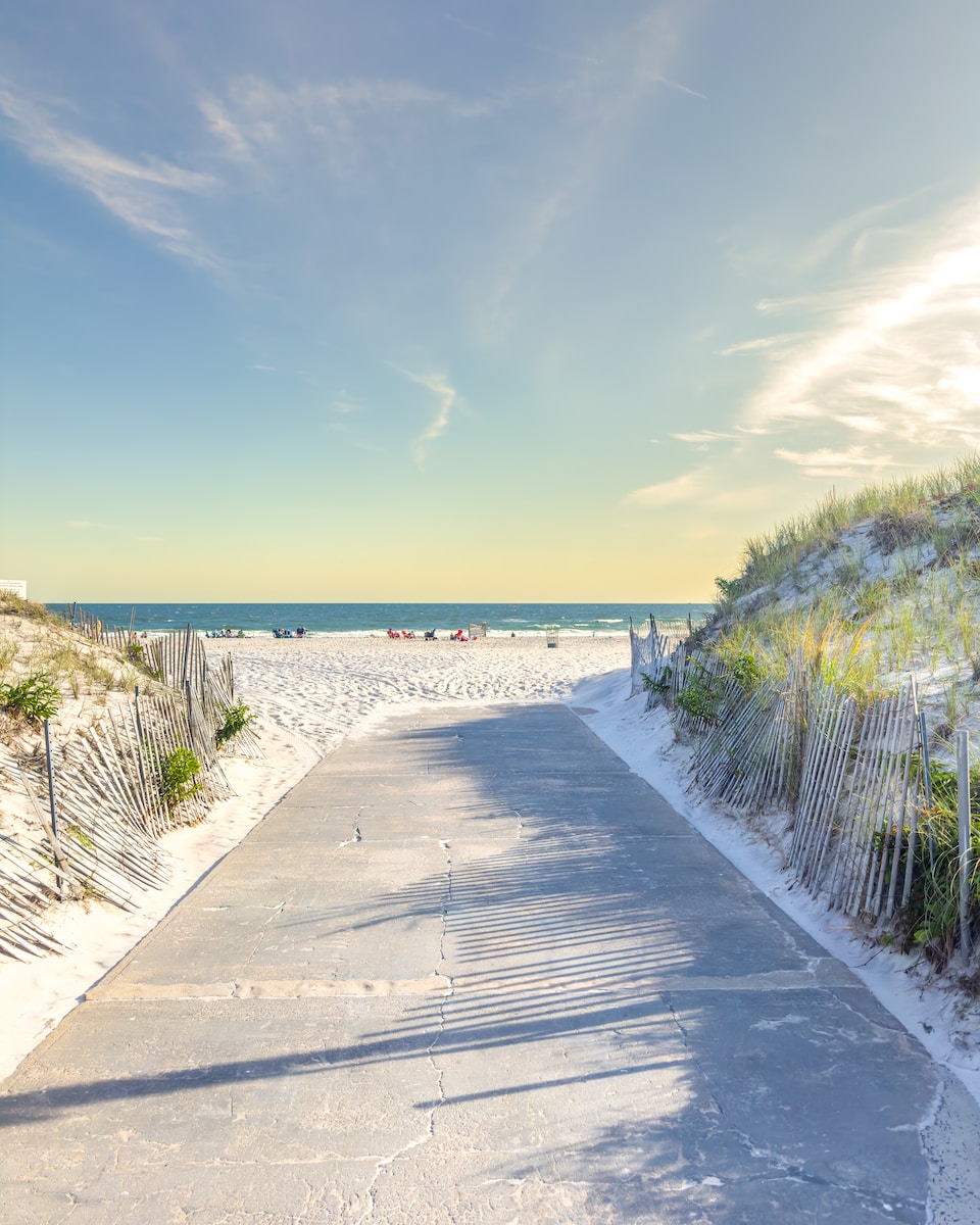 a sandy beach with a path leading to the ocean